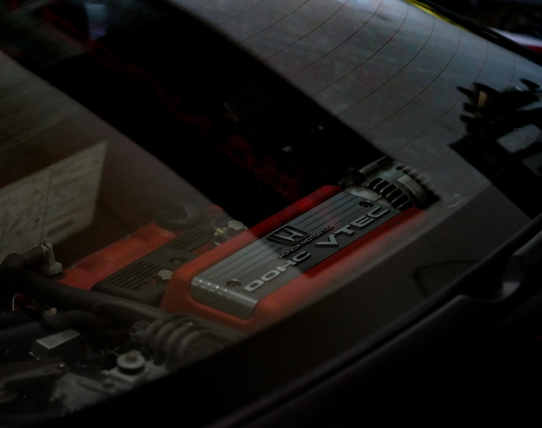 Close-up photo of a VTEC engine cover seen through a rear window