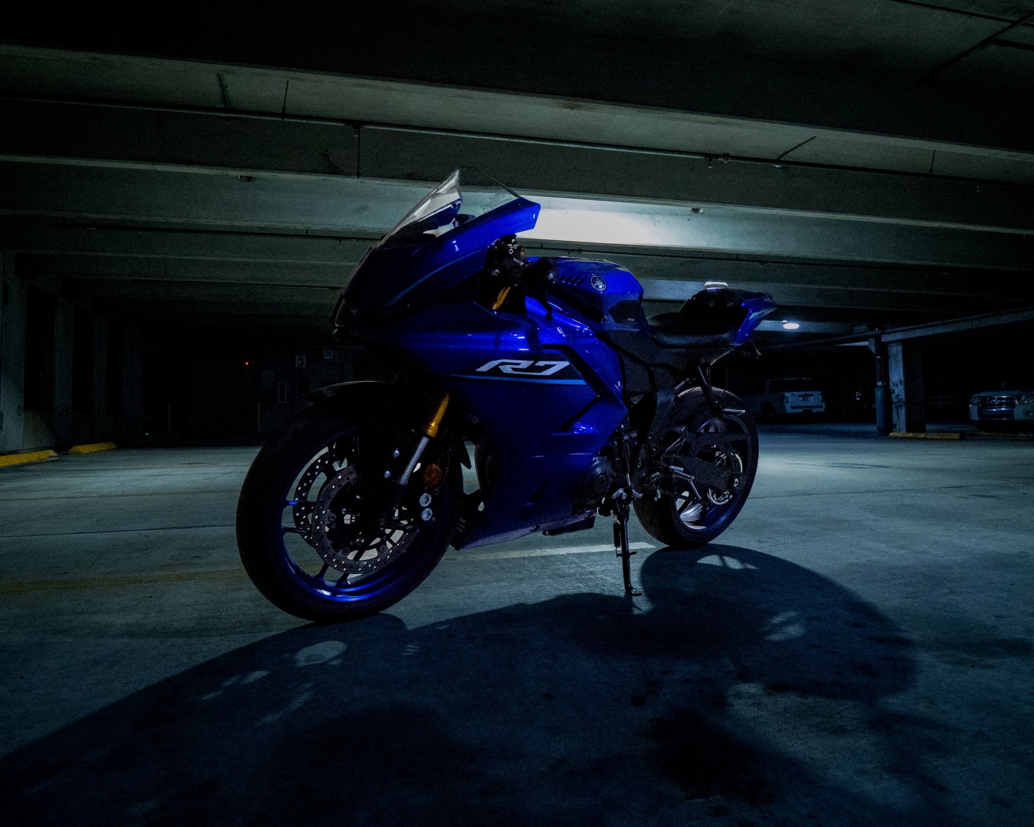 Blue sport motorcycle photographed at night in a parking garage