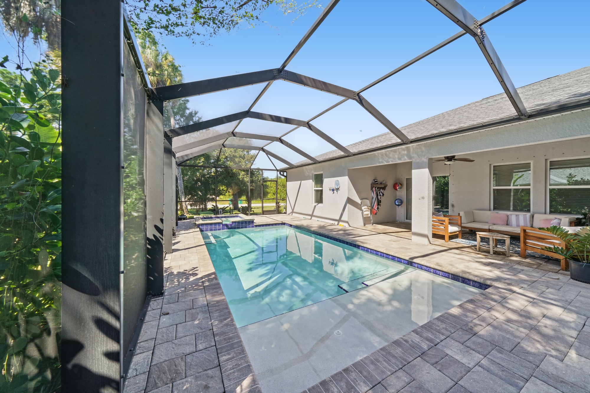Screened pool and lanai photographed on a sunny Florida day